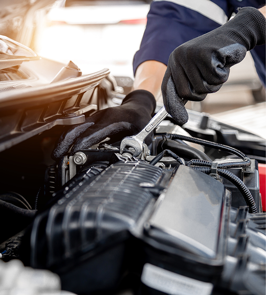 Mechanic tightening bolt on car engine.