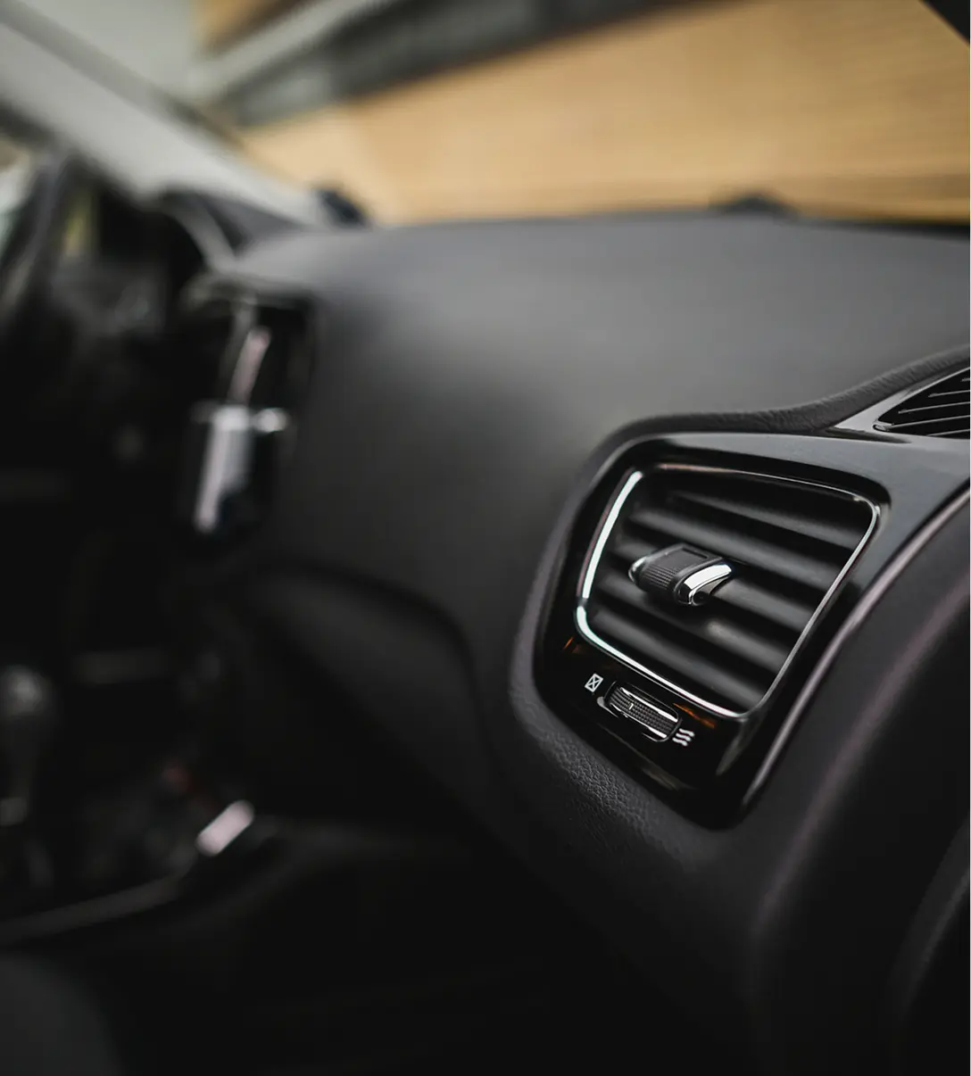 Car interior focusing on air vent controls.
