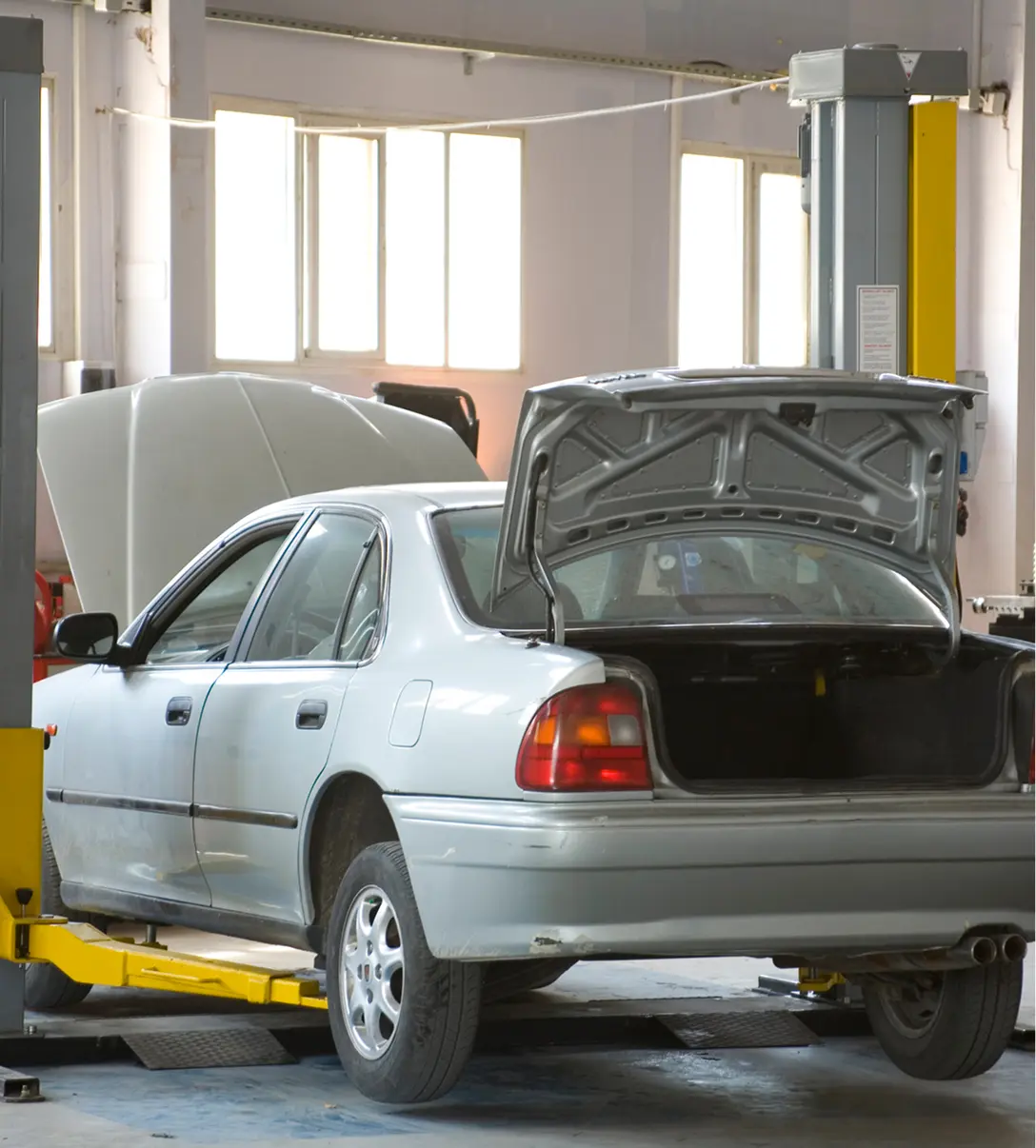 Car on lift in auto repair shop.