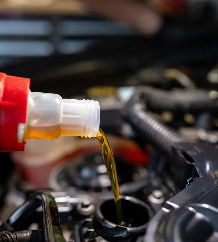Pouring oil into car engine.